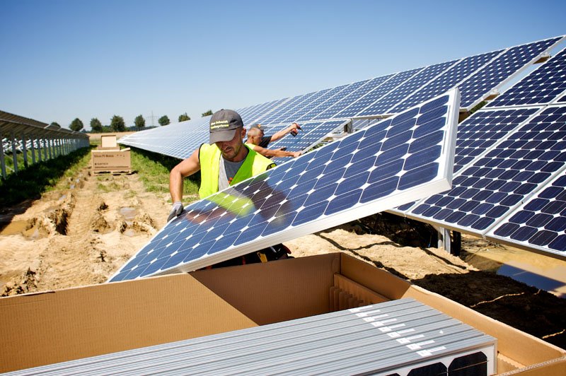 engineer installing solar panels in solar farm